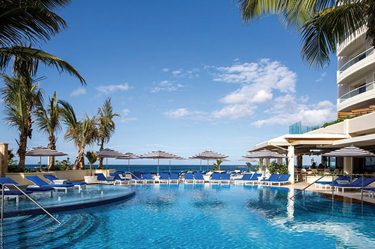 A resort style pool in San Juan, Puerto Rico, overlooking a view of the ocean.